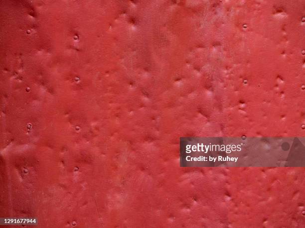 background of a red metal plate with dents - abollado fotografías e imágenes de stock