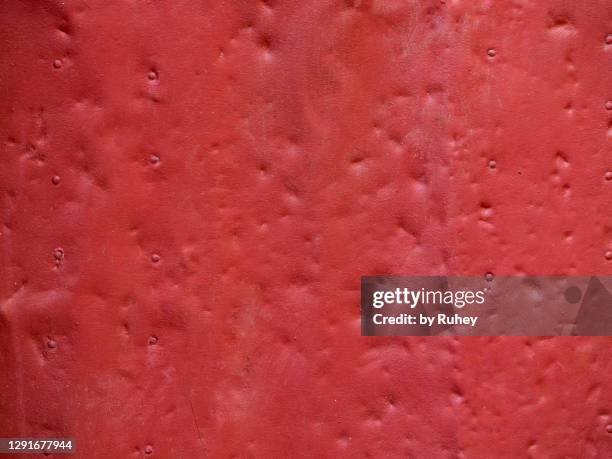 background of a red metal plate with dents - dents stock pictures, royalty-free photos & images