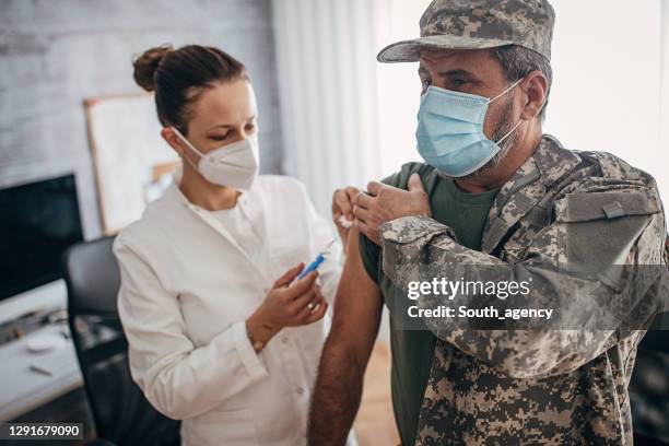 militär soldat få snabb covid-19 vaccin i läkarmottagningen - military arm bildbanksfoton och bilder