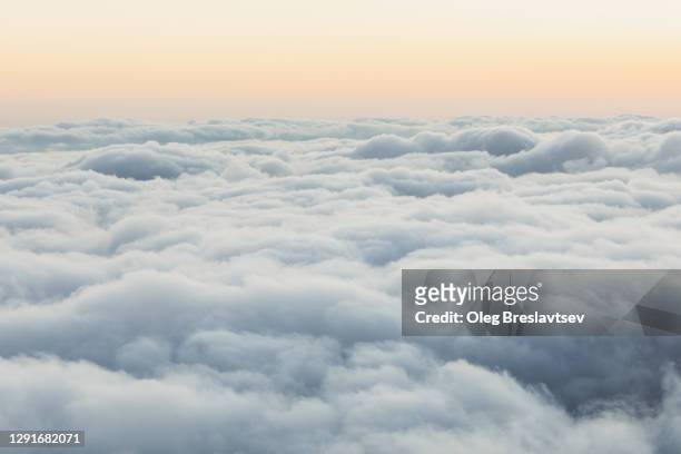 nature background of sky with room for copy space. view of low clouds from above at sunset - cloud sky stock-fotos und bilder