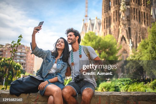 Young Couple Taking Break from Sightseeing for Selfie Young Couple Taking Break from Sightseeing for Selfie