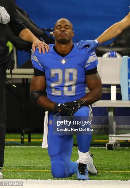 Adrian Peterson of the Detroit Lions kneel during the national anthem before their game against the Green Bay Packers at Ford Field on December 13,...