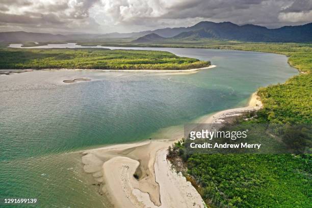 river bend, sand, beach, trees, mountain range and clouds - daintree australia stock pictures, royalty-free photos & images