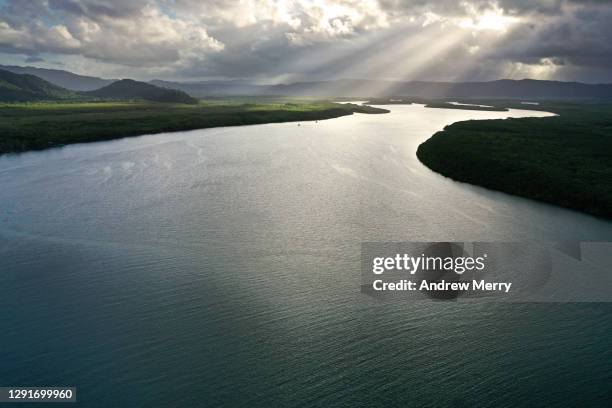 wide river, estuary, clouds with sunbeams at sunset - daintree australia stock pictures, royalty-free photos & images