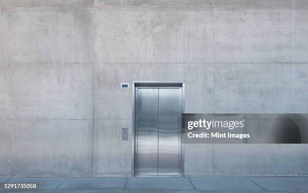 metal elevator doors in a concrete wall. - elevator fotografías e imágenes de stock