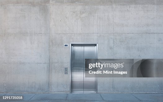 Metal elevator doors in a concrete wall. Metal elevator doors in a concrete wall.