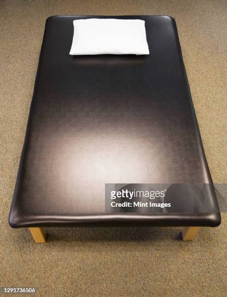 high angle view of leather massage or treatment couch. - massage table stock pictures, royalty-free photos & images