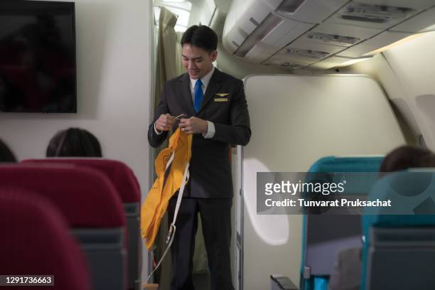 air hostess staff airline demonstrate safety procedures to passengers prior to flight take off in cabin airplane. - hosts economics conference stock pictures, royalty-free photos & images