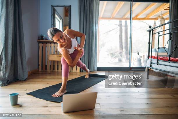 bella giovane donna che fa yoga a casa - home workout foto e immagini stock