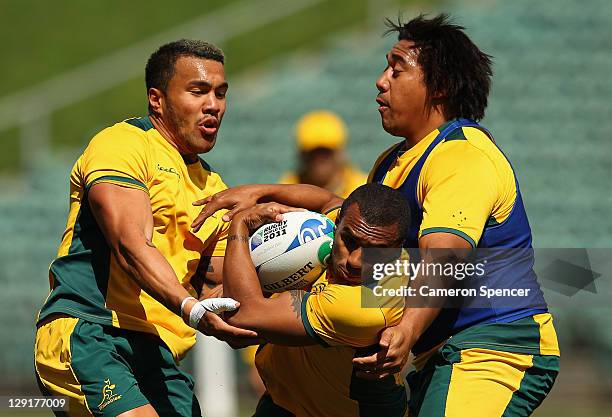 Digby Ioane and Salesi Ma'afu of the Wallabies tackle Will Genia during an Australia IRB Rugby World Cup 2011 training session at North Harbour...