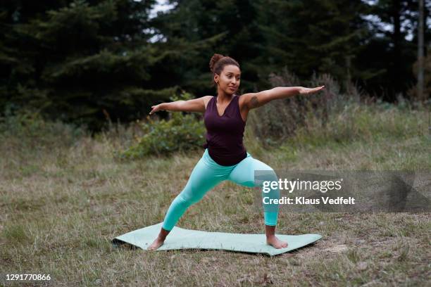 woman practicing warrior position in forest - warrior position stock pictures, royalty-free photos & images