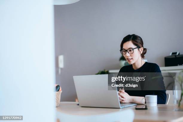 young asian woman working from home, having video conference on laptop at home - e learning asian stock pictures, royalty-free photos & images