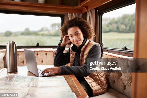 smiling woman sitting with laptop in motor home - flask stock pictures, royalty-free photos & images