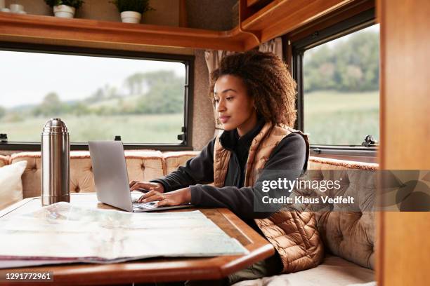 woman using laptop in camper van - navigare in internet fotografías e imágenes de stock