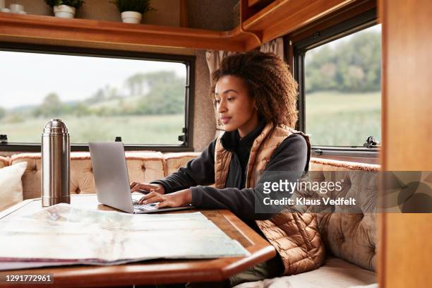 woman using laptop in camper van - time off work stock pictures, royalty-free photos & images