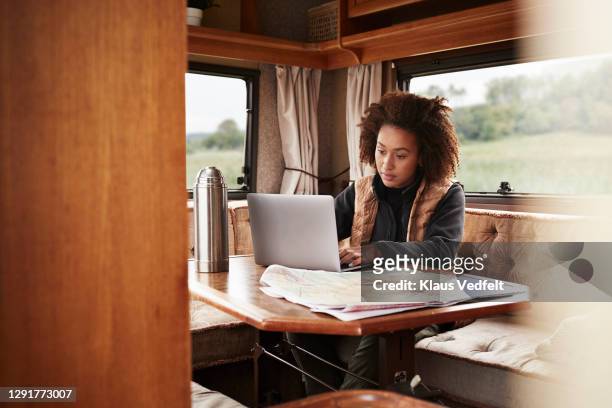 woman using laptop while sitting in camper van - freelance work stock pictures, royalty-free photos & images