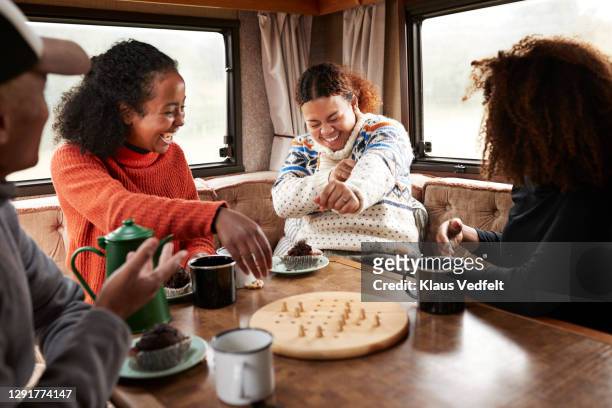 friends having fun while playing board in motor home - 4 people playing games stock-fotos und bilder