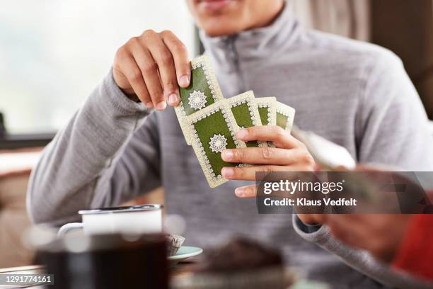 man playing cards with friend in motor home - hand of cards stock-fotos und bilder