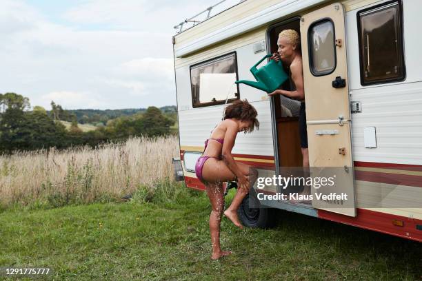 woman having bath outside motor home - shower man woman washing foto e immagini stock