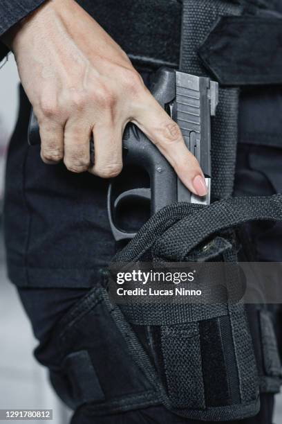 woman holding gun in holster - holster stock pictures, royalty-free photos & images