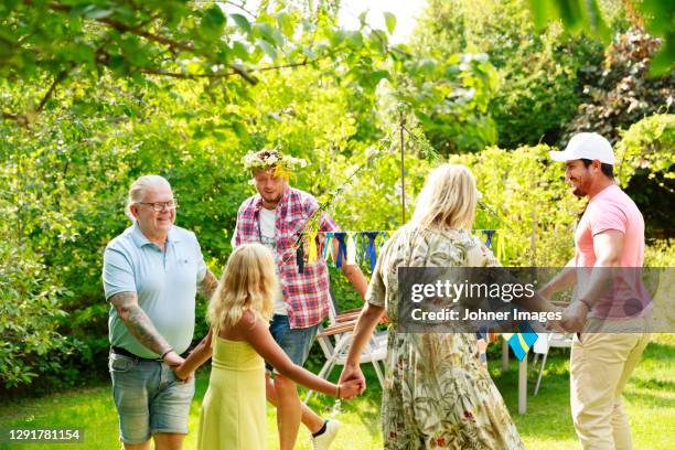 family dancing in garden around maypole - midsommar stock pictures, royalty-free photos & images