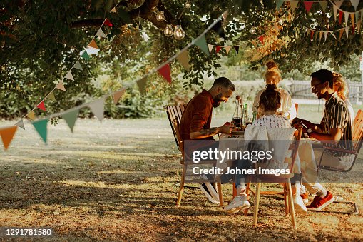 People having meal in garden People having meal in garden