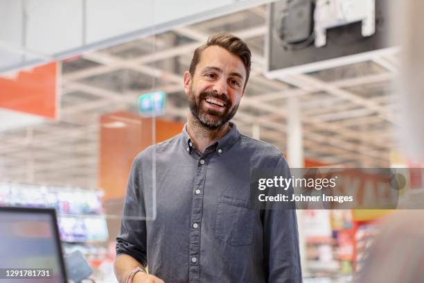 smiling client at till - shop till stockfoto's en -beelden