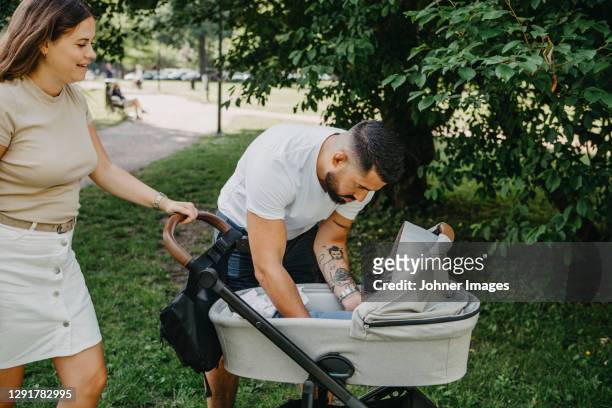 parents with pram in park - carriage stock pictures, royalty-free photos & images
