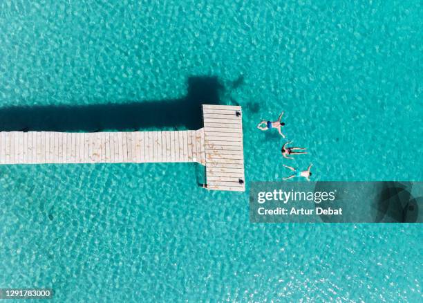 aerial view of three friends diving into the sea in mallorca island during summer. - group-of-friends-jumping-off-dock-into-lake stock pictures, royalty-free photos & images