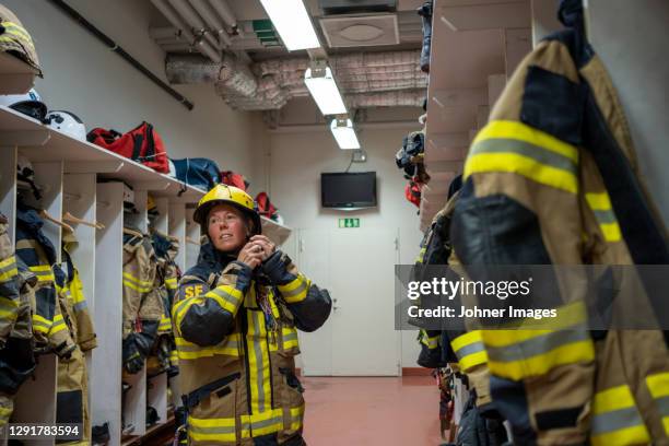 female firefighter changing in locker - firemen at work stock pictures, royalty-free photos & images