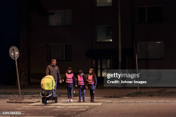 father with children walking at evening - reflector objeto fabricado fotografías e imágenes de stock
