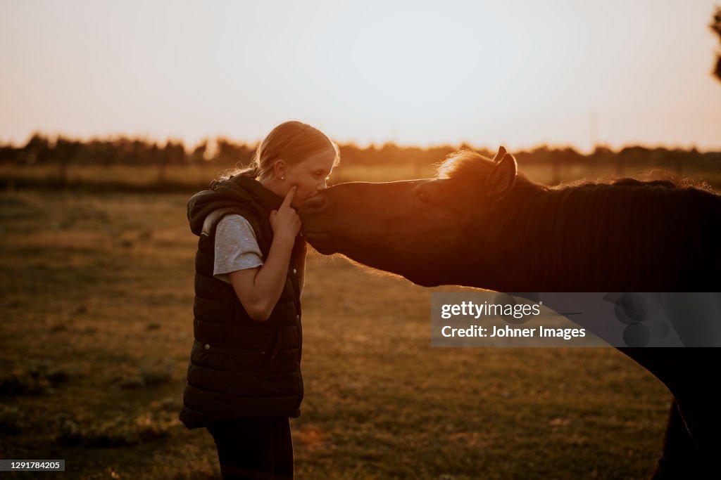 Girl with pony on meadow