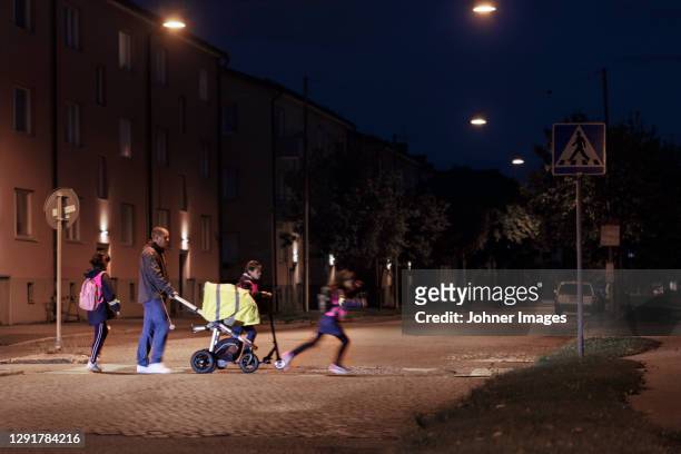 father with children walking in evening - reflector stock pictures, royalty-free photos & images
