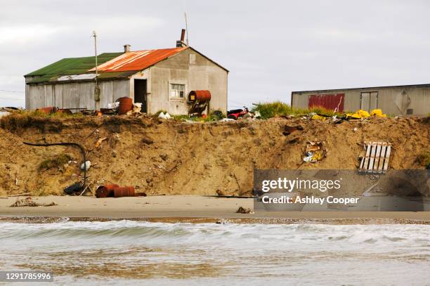 houses close to the edge following rapid coastal erosion on shishmaref a tiny island between alaska and siberia in the chukchi sea. - houses of alaska stock pictures, royalty-free photos & images