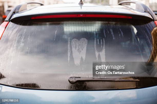 i love you written with simbols on the wet rear window of a car - car window stockfoto's en -beelden