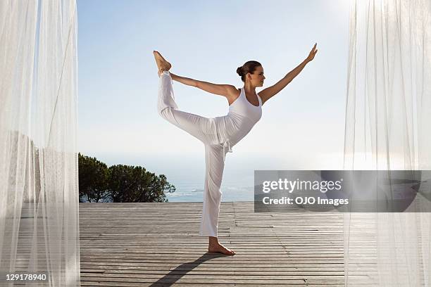 teenage girl exercising against clear sky - yoga flexibility stock pictures, royalty-free photos & images