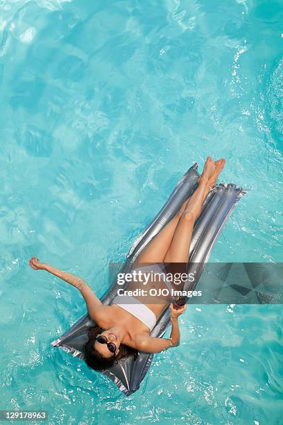 mulher segurando a taça, deitados sobre bote - women sunbathing pool - fotografias e filmes do acervo