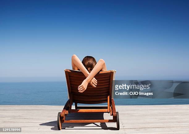 vista traseira de mulher na cadeira de recosto - women by pool imagens e fotografias de stock