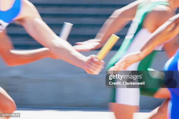 four male runners passing relay baton - stafett bildbanksfoton och bilder