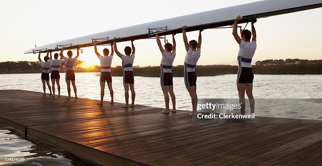 Athletics carrying a crew canoe over heads