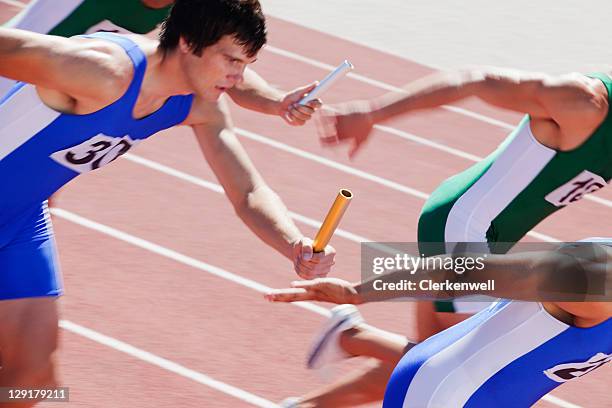 racers running on track with relay baton - stafett bildbanksfoton och bilder