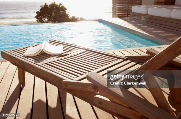 libro aperto con chaise longue a bordo piscina - sedia a sdraio foto e immagini stock