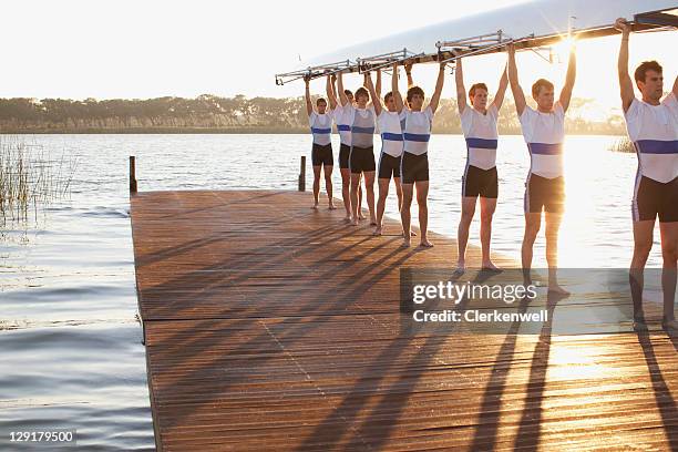 atletas organizar su barco hacia arriba - remo de competición fotografías e imágenes de stock