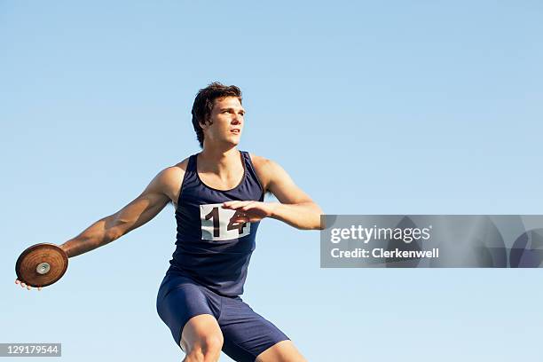 man throwing discus against sky - discus stock pictures, royalty-free photos & images