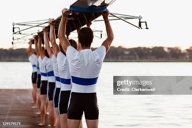 equipo de máquinas de remos llevar una tripulación canoa con cabezales - deporte de equipo fotografías e imágenes de stock