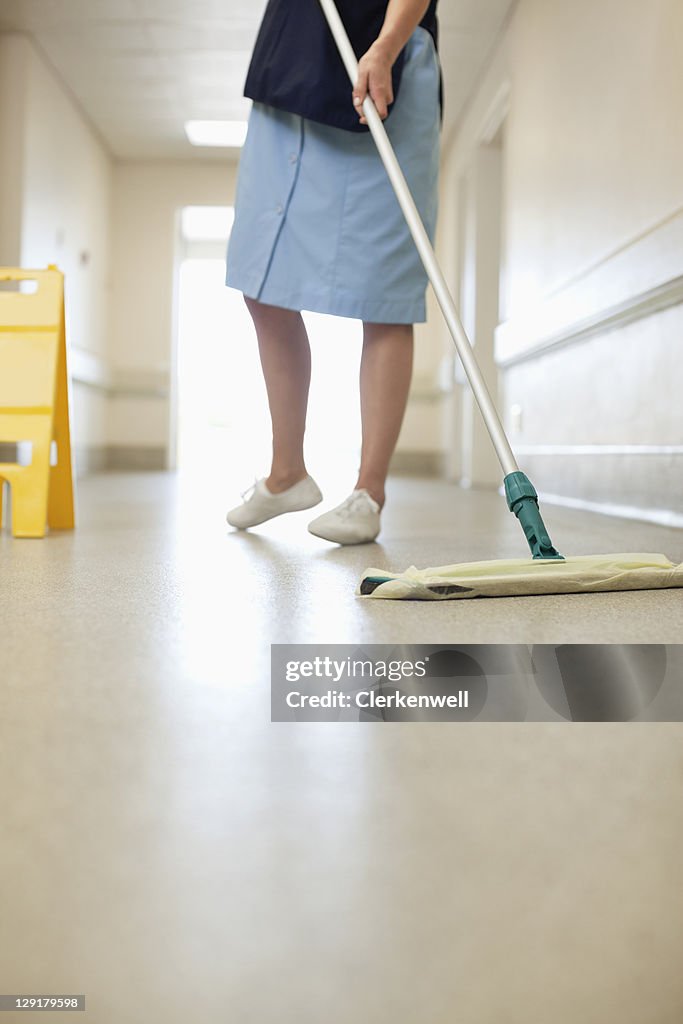 Low section of woman cleaning floor