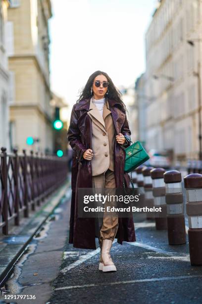 Gabriella Berdugo wears sunglasses, a white turtleneck pullover, earrings, a necklace, a bi color beige and brown oversized blazer jacket and suit...