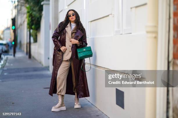 Gabriella Berdugo wears sunglasses, a white turtleneck pullover, earrings, a necklace, a bi color beige and brown oversized blazer jacket and suit...