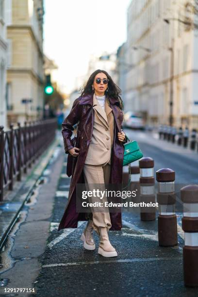 Gabriella Berdugo wears sunglasses, a white turtleneck pullover, earrings, a necklace, a bi color beige and brown oversized blazer jacket and suit...