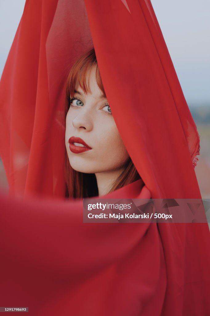 Young woman draped in red fabric outdoors,Novi Sad,Serbia